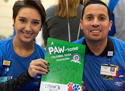 The 25th anniversary event featured a coloring book representing the program’s 25 years. SLCH volunteer Anna Moore, left, who has a bachelor of fine arts degree in graphic design and is pursuing a master of arts degree in art therapy counseling, created the cover art for the coloring book. The dogs’ individual pages in the coloring book were drawn by Frank Duarte, Children’s Specialty Care Center site coordinator, right, who’s loved art from a very young age. 